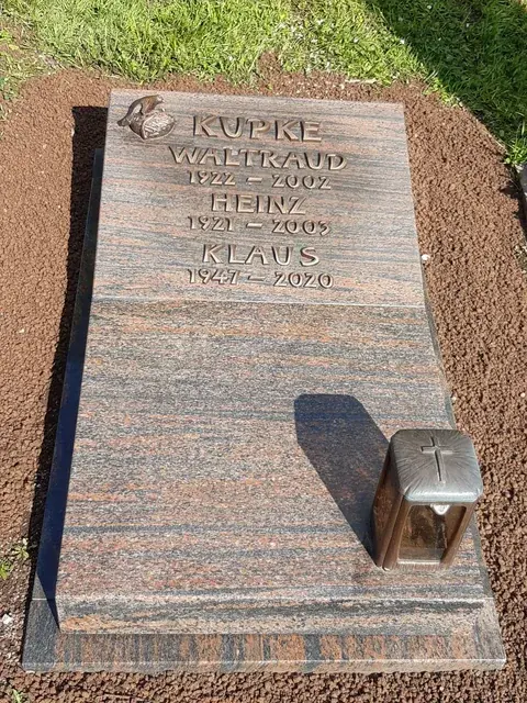 Liegender Grabstein mit Inschrift auf einer Grabstätte